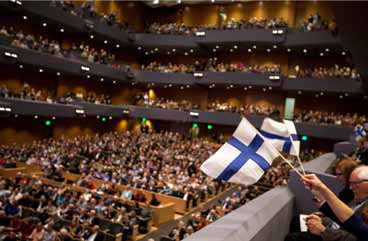 The Finnish flags are evidence of the extreme blue and white fever at the sold-out March 29 Minnesota Orchestra concert in Orchestra Hall conduct- ed by Osmo Vänskä. Audience members brought flags and banners, wore blue and white clothting, and even sported makeup representing the Finn- ish flag, all in a “Finnish It” campaign to convince the Minnesota board to rehire Vänskä as music director. The efforts paid off. On April 24 the board announced that Vänskä would return as music director.Photo credit: Courtney Perry